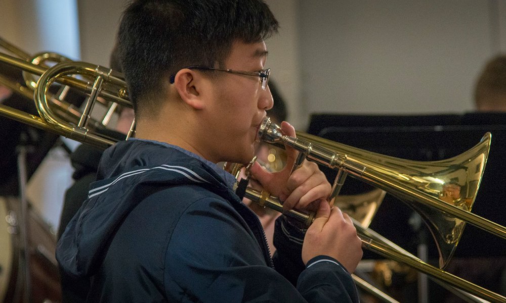 Yan “Anson” Kai, Collin student and musician plays trombone at a concert rehearsal