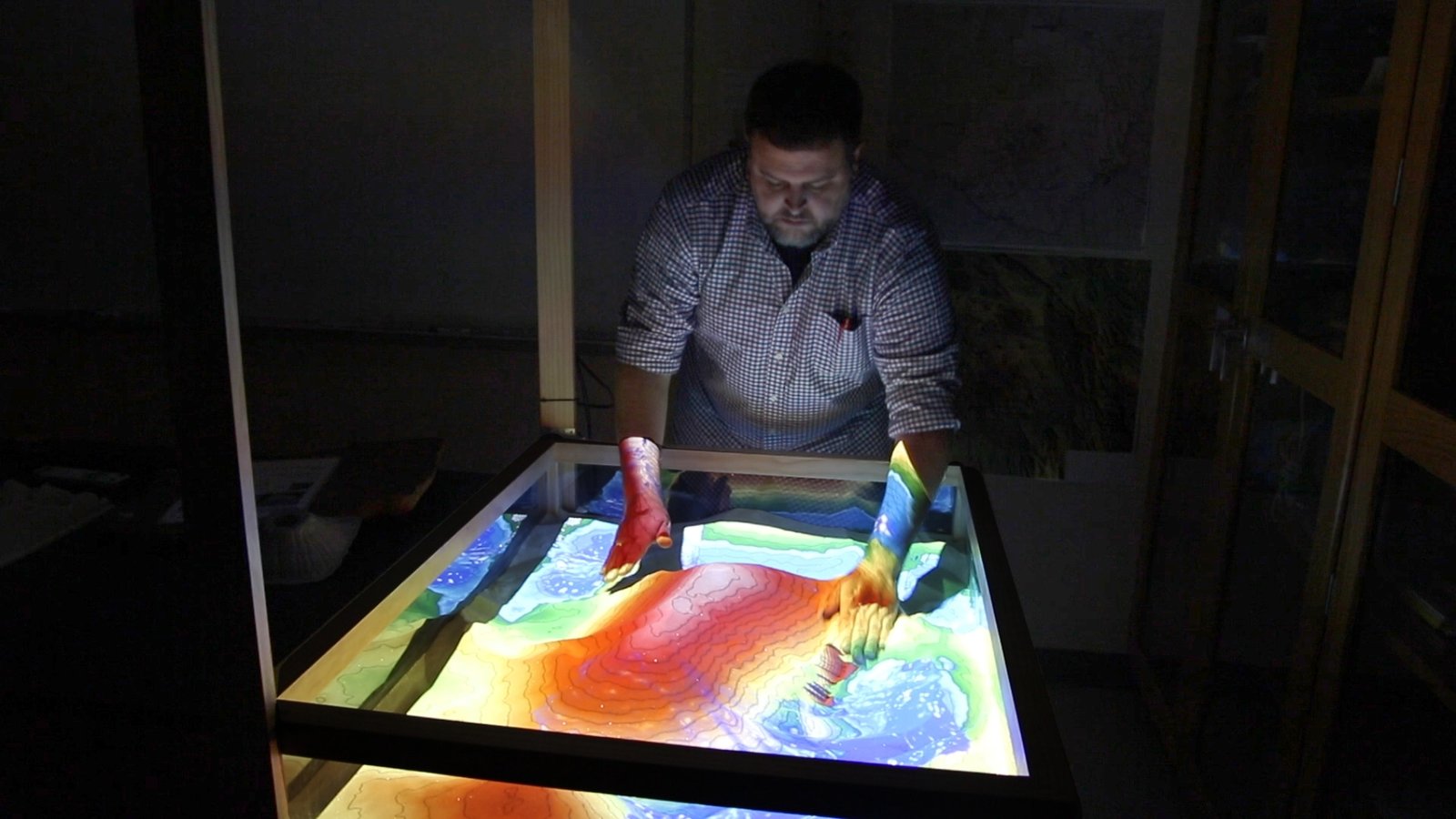 A professor demonstrates the Augmented Reality Sandbox at Collin College's Plano Campus.