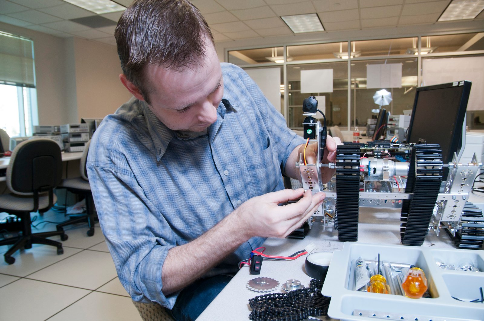 An individual works on a robot.
