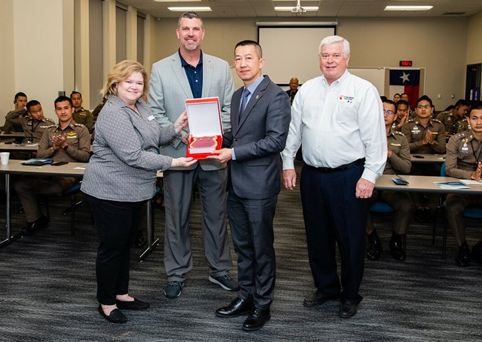 A dignitary from the Royal Thai Police exchanges a gift of friendship with Collin College officials. Photo by SARA CARPENTER